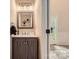 Charming half bath offers a decorative vanity with a framed mirror and a door to the home's entrance at 7810 Leisure Ln, Huntersville, NC 28078
