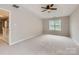 Large bedroom with neutral walls and carpet features a window and a ceiling fan at 7810 Leisure Ln, Huntersville, NC 28078