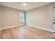 Light-filled bedroom with hardwood floors, window, and a clean design creating a modern look at 7810 Leisure Ln, Huntersville, NC 28078