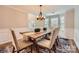 Elegant dining room with wainscoting, a rustic wood table, and modern chandelier at 7810 Leisure Ln, Huntersville, NC 28078