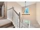 Staircase with modern chandelier illuminating the entry and white banisters at 7810 Leisure Ln, Huntersville, NC 28078