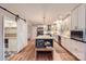 Bright kitchen features an island with seating, stainless appliances, and a large pantry with sliding barn door at 7810 Leisure Ln, Huntersville, NC 28078
