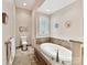Bathroom featuring a soaking tub, tiled floors, and neutral tones at 8026 Greenview Terrace Ct, Charlotte, NC 28277