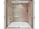 Modern bathroom showcases a bathtub with a shower and decorative tile surround and glass door at 8026 Greenview Terrace Ct, Charlotte, NC 28277