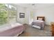 Sunlit bedroom featuring two twin beds, neutral walls, and plantation shutters for privacy at 8026 Greenview Terrace Ct, Charlotte, NC 28277