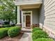 Inviting front entrance with stone accents, mature landscaping, and a covered porch at 8026 Greenview Terrace Ct, Charlotte, NC 28277
