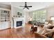Stylish living room with a cozy fireplace, built-in shelving, and large windows at 8026 Greenview Terrace Ct, Charlotte, NC 28277