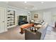 A comfortable living room with built-in shelving, neutral walls, plush carpet, and a ceiling fan at 8026 Greenview Terrace Ct, Charlotte, NC 28277