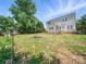 Spacious backyard with a lush lawn, mature trees, and a charming fire pit area at 8304 Prescott Glen Pkwy, Waxhaw, NC 28173