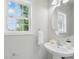Clean and simple powder room with a pedestal sink, modern mirror, and bright natural light at 8304 Prescott Glen Pkwy, Waxhaw, NC 28173