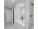Modern bathroom with a tub under a window and tiled walls throughout the space at 8304 Prescott Glen Pkwy, Waxhaw, NC 28173
