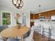 Bright dining area featuring wood cabinets, bar seating, and a stylish round table at 8304 Prescott Glen Pkwy, Waxhaw, NC 28173
