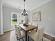 An inviting dining room features neutral colors, a chandelier, and views of a lush green lawn at 8304 Prescott Glen Pkwy, Waxhaw, NC 28173