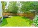 Spacious backyard with well-maintained lawn, wooden fence, stone patio and lush green trees at 904 Anderson St, Charlotte, NC 28205