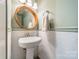 Stylish powder room featuring pedestal sink, round mirror, and decorative wallpaper at 904 Anderson St, Charlotte, NC 28205