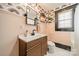 Well-lit bathroom with modern vanity, patterned wallpaper, and a window at 904 Anderson St, Charlotte, NC 28205