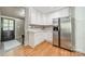 Bright kitchen featuring stainless steel refrigerator, white cabinets, and hardwood floors at 904 Anderson St, Charlotte, NC 28205