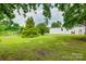 Wide shot of the backyard with mature trees and green grass at 976 Neely Store Rd, Rock Hill, SC 29730