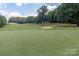 Scenic golf course view featuring lush green fairways and mature trees on a sunny day at 10209 Green Tee Ln, Charlotte, NC 28277