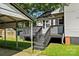 View of the back deck with black railings and adjacent carport and greenhouse at 1072 5Th Ne St, Hickory, NC 28601