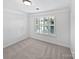 Light filled bedroom with neutral carpet and a window with white shutters at 1090 Mclaren Dr, Belmont, NC 28012
