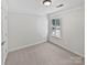 Bright bedroom with neutral carpet, white walls and trim, and a window with white shutters at 1090 Mclaren Dr, Belmont, NC 28012