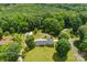An aerial view displays a home with a lush green lawn surrounded by trees, and a detached garage at 111 Kelly Ln, Gastonia, NC 28056