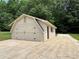 Detached garage with side entrance, stylish doors and concrete driveway surrounded by lush greenery at 111 Kelly Ln, Gastonia, NC 28056