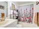 Functional bathroom with floral shower curtain, storage shelves, and white fixtures creating a clean, organized space at 1116 Crestview Dr, Salisbury, NC 28146