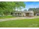 Inviting single story home boasts a long driveway, attached covered parking, and well-maintained front yard with mature trees at 1116 Crestview Dr, Salisbury, NC 28146