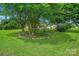 Landscaped front yard featuring a tree ring with stones and lush green grass at 1116 Crestview Dr, Salisbury, NC 28146