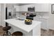 Modern kitchen showcases white cabinets, stainless appliances, a large quartz island with barstool seating, and sleek fixtures at 1202 Elm Forest Ln, China Grove, NC 28023