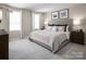 Serene main bedroom with plush carpeting, large windows, elegant bedding, and stylish decor at 1202 Elm Forest Ln, China Grove, NC 28023