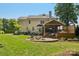Expansive backyard with stone patio, fire pit, built in barbeque, and a screened in back porch at 122 Ringneck Trl, Mooresville, NC 28117