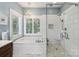 Bathroom featuring a glass-enclosed shower, soaking tub, marble floors, and a chandelier at 122 Ringneck Trl, Mooresville, NC 28117