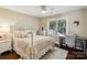 Cozy bedroom with hardwood floors, a decorative iron bed, and natural light from a nearby window at 122 Ringneck Trl, Mooresville, NC 28117