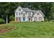 Beautiful two-story white brick home with a manicured lawn, bright blue front door, and mature landscaping at 122 Ringneck Trl, Mooresville, NC 28117