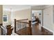 Hallway with wood floors, iron railing, and a view into the main bedroom with a chandellier at 122 Ringneck Trl, Mooresville, NC 28117
