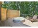 Back deck with a round hot tub and a wooden fence for privacy surrounded by mature trees at 122 Ringneck Trl, Mooresville, NC 28117