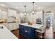 Spacious kitchen features a large island with seating, stainless steel appliances and stylish pendant lighting at 122 Ringneck Trl, Mooresville, NC 28117