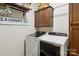 Organized laundry room with new front loading washer and dryer, storage shelves, and wooden cabinets at 122 Ringneck Trl, Mooresville, NC 28117