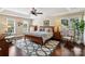 Bright main bedroom with tray ceilings, hardwood floors, large windows, and comfortable seating at 122 Ringneck Trl, Mooresville, NC 28117