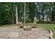 Secluded stone patio with a built in fire pit perfect for entertaining on a manicured lawn at 122 Ringneck Trl, Mooresville, NC 28117