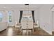 Dining room with a wooden table, seating for six, modern chandelier, and a large window with black curtains at 12615 Es Draper Dr, Huntersville, NC 28078