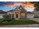 Charming home with stone accents, manicured lawn, and well-maintained landscape under beautiful sunset colors at 12615 Es Draper Dr, Huntersville, NC 28078