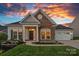 Charming home featuring stone accents, manicured landscaping, and a welcoming front porch at 12615 Es Draper Dr, Huntersville, NC 28078