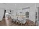 A kitchen features an island with granite countertops and white cabinets with seating for three and stainless steel appliances at 12615 Es Draper Dr, Huntersville, NC 28078