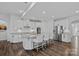 The kitchen features an island with granite countertops, stainless steel appliances, and white cabinets with seating for three at 12615 Es Draper Dr, Huntersville, NC 28078