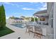 Resort-style backyard showcases an outdoor kitchen with seating and a stunning pool with lounge chairs at 12615 Es Draper Dr, Huntersville, NC 28078