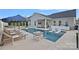 A beautiful pool with a fire pit, sun loungers, spa, and outdoor kitchen, creates the perfect outdoor oasis at 12615 Es Draper Dr, Huntersville, NC 28078